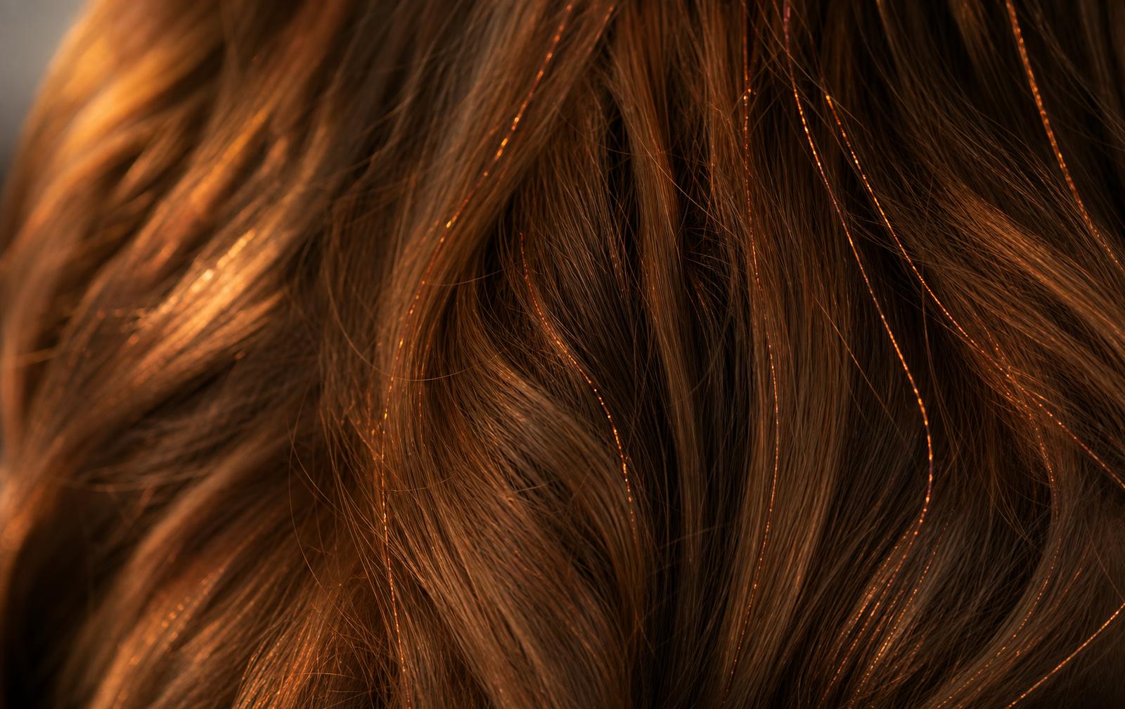 Bronzed Ember LUMILOX strands woven through real hair